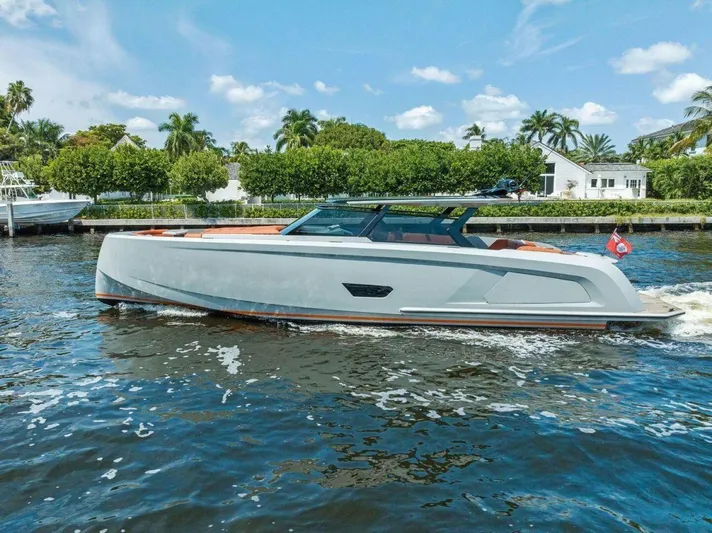 Incentivized Yacht Photos Pics 2021 Vanquish VQ58 yacht cruising on a sunny day, surrounded by lush greenery.