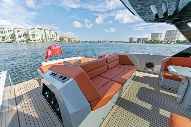 Incentivized Yacht Photos Pics Luxury Vanquish VQ58 yacht deck with orange seating, city skyline, and water view.
