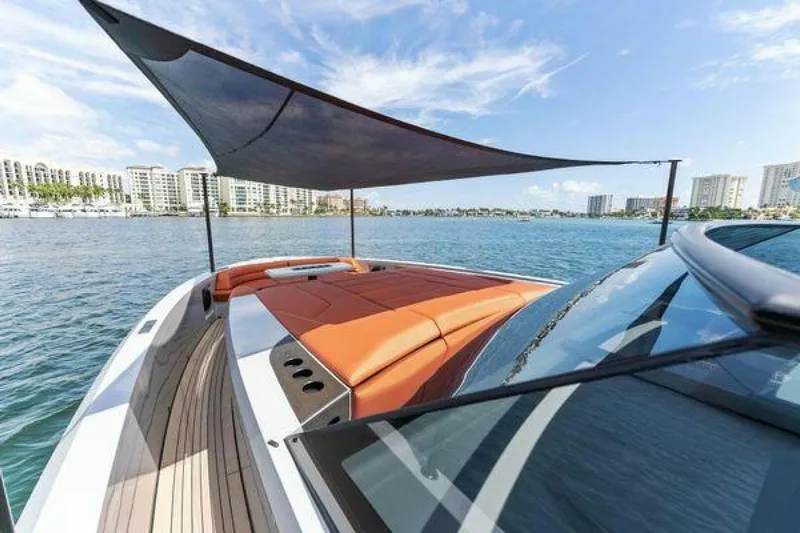 Incentivized Yacht Photos Pics Luxury Vanquish VQ58 yacht with sunshade, docked near waterfront buildings, 2021 model.