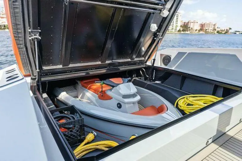 Incentivized Yacht Photos Pics 2021 Vanquish VQ58 yacht with open storage compartment, featuring a jet ski and equipment.