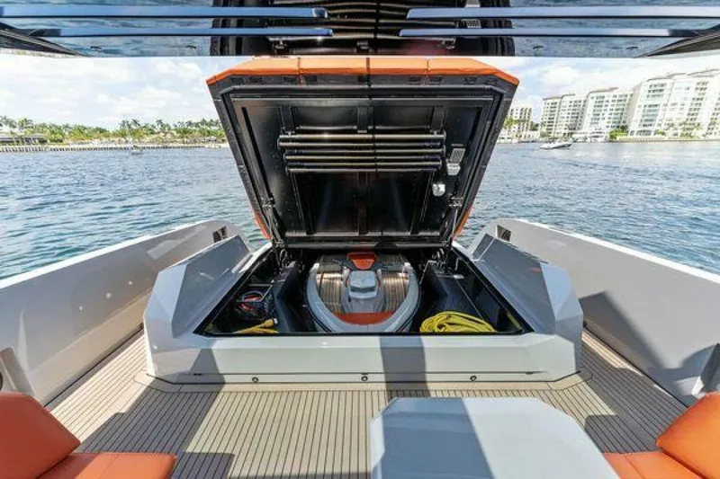 Incentivized Yacht Photos Pics 2021 Vanquish VQ58 yacht with open engine compartment, docked near waterfront buildings.