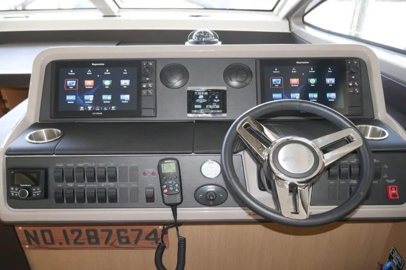 Necessity Yacht Photos Pics Control panel of 2017 Sea Ray Fly 400 yacht with steering wheel and navigation screens.
