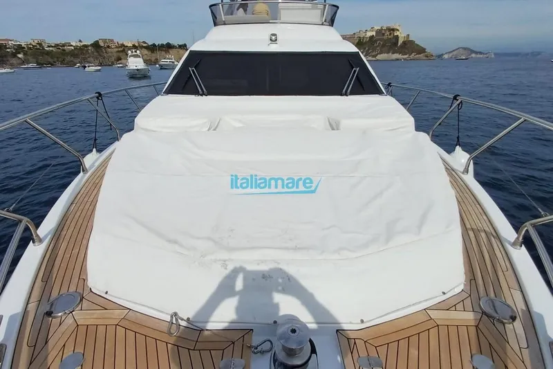  Yacht Photos Pics 2025 Azimut Fly 60 yacht deck with cover, docked in scenic coastal waters.