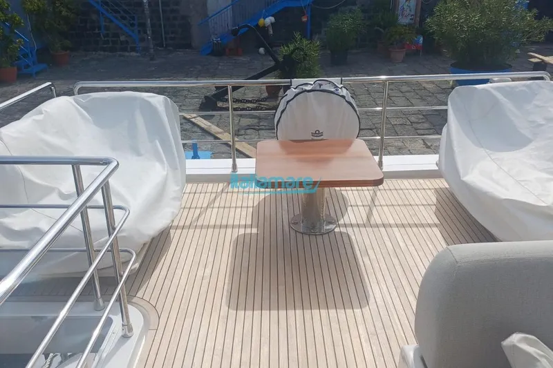  Yacht Photos Pics Deck of 2025 Azimut Fly 60 yacht with covered seating and wooden table.