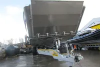 Boat on trailer, Robust LC1227, 2023 model, parked outdoors on wet pavement.