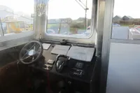 Interior of a 2023 Robust LC1227 boat with steering wheel and navigation equipment.