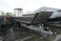 2023 Robust LC1227 boat on trailer in industrial setting.