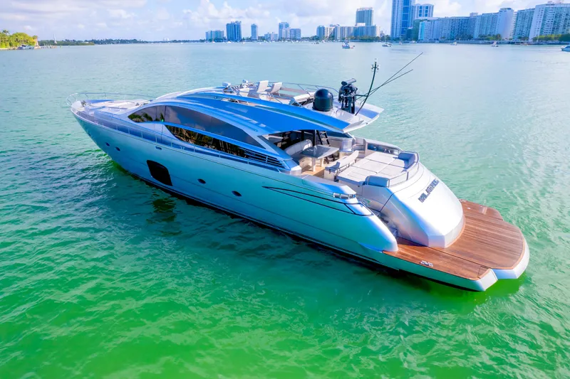  Yacht Photos Pics Luxurious 2013 Pershing 82 yacht cruising in clear turquoise waters near a city skyline.