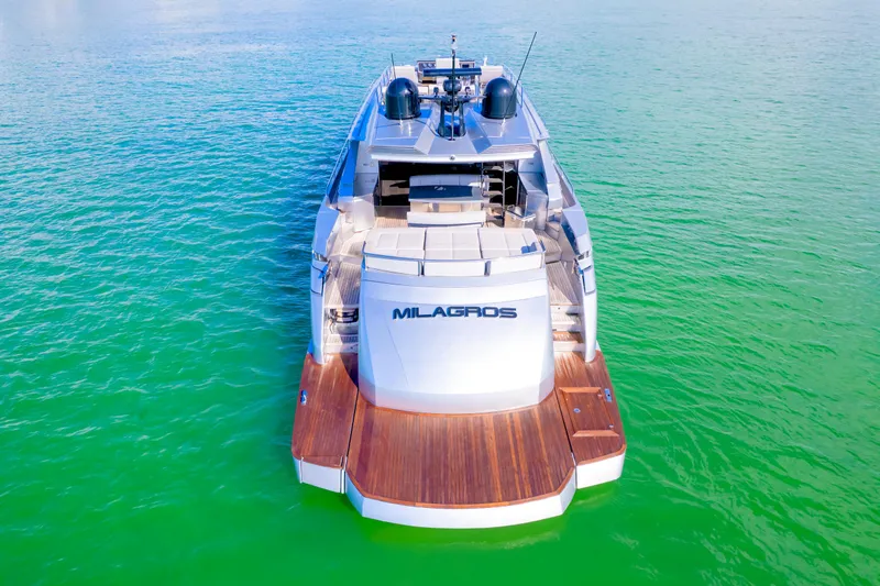  Yacht Photos Pics Luxury Pershing 82 yacht from 2013 on vibrant green water, rear view.