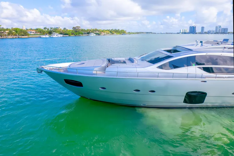  Yacht Photos Pics Luxury 2013 Pershing 82 yacht on clear blue water, sunny day, coastal skyline.