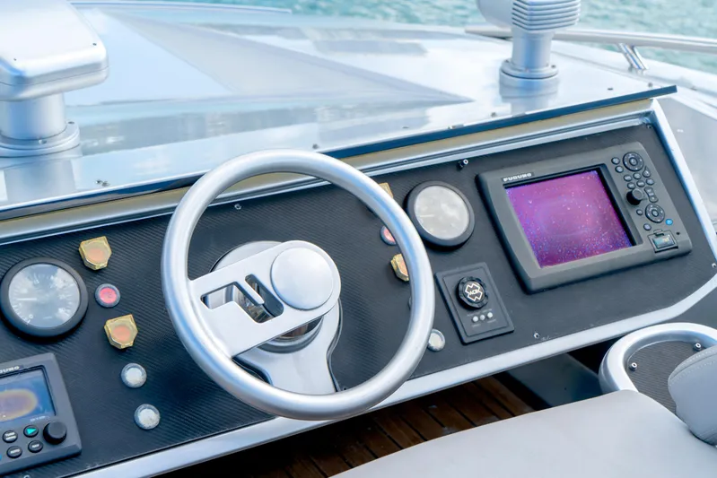  Yacht Photos Pics Control panel of a 2013 Pershing 82 yacht with steering wheel and navigation display.