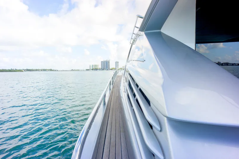  Yacht Photos Pics Luxury Pershing 82 yacht cruising on calm waters, 2013 model, with city skyline in background.