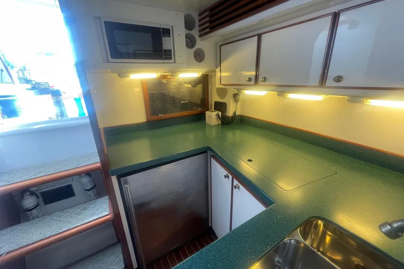 M.a.c. Daddy Yacht Photos Pics 2005 Custom DeSanti Carolina Express boat kitchen with green countertops and modern appliances.