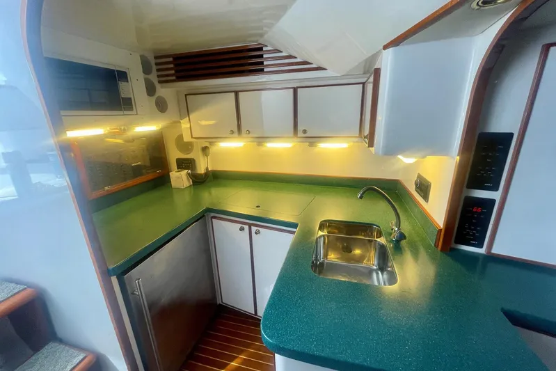 M.a.c. Daddy Yacht Photos Pics Compact kitchen in 2005 Custom DeSanti Carolina Express boat with green countertops and stainless steel sink.