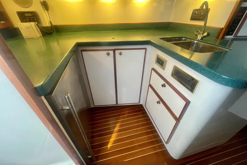 M.a.c. Daddy Yacht Photos Pics Compact kitchen area in a 2005 Custom DeSanti Carolina Express boat with green countertops.