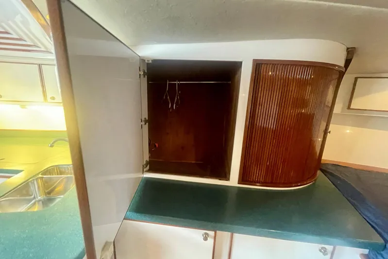 M.a.c. Daddy Yacht Photos Pics Interior of 2005 Custom DeSanti Carolina Express with open wooden cabinet and green countertop.