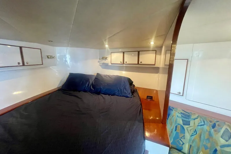 M.a.c. Daddy Yacht Photos Pics Cozy cabin interior of 2005 Custom DeSanti Carolina Express with bed and storage cabinets.