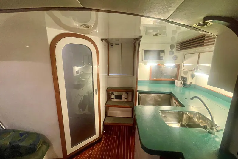 M.a.c. Daddy Yacht Photos Pics Interior of 2005 Custom DeSanti Carolina Express boat with kitchenette and wooden flooring.