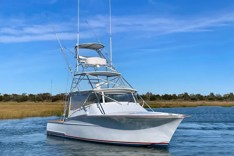 M.a.c. Daddy Yacht Photos Pics Custom 2005 DeSanti Carolina Express boat on calm water under clear blue sky.