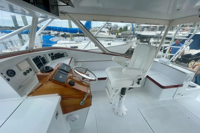 M.a.c. Daddy Yacht Photos Pics Helm of 2005 Custom DeSanti Carolina Express boat with white captain's chair and wooden console.