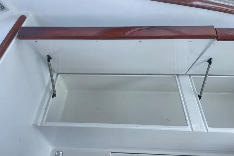 M.a.c. Daddy Yacht Photos Pics Storage compartment on a 2005 Custom DeSanti Carolina Express boat with wooden trim.