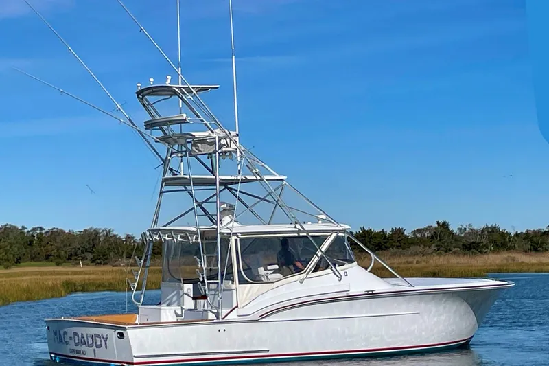 M.a.c. Daddy Yacht Photos Pics Custom 2005 DeSanti Carolina Express boat on calm water with clear blue sky.