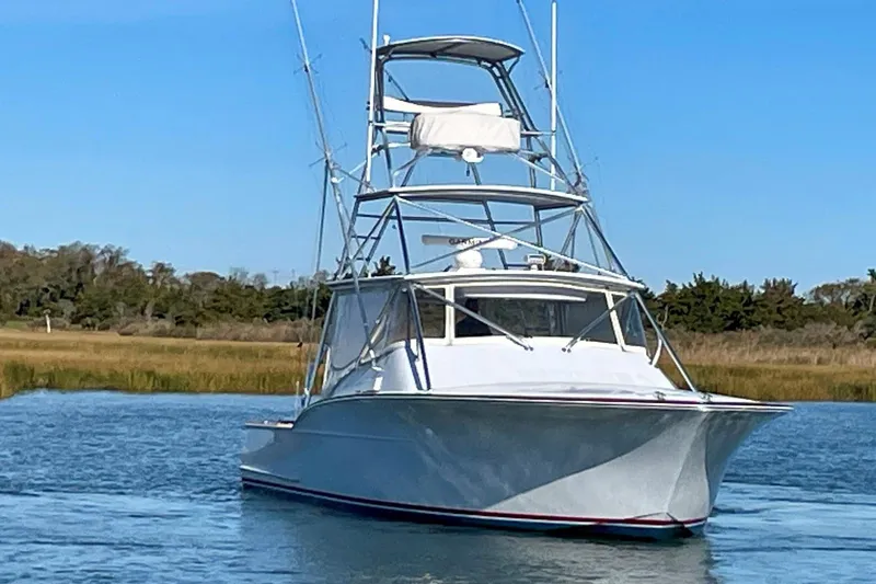 M.a.c. Daddy Yacht Photos Pics Custom 2005 DeSanti Carolina Express boat on calm water, clear sky background.