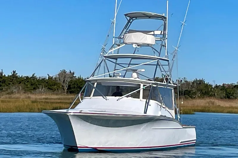M.a.c. Daddy Yacht Photos Pics Custom 2005 DeSanti Carolina Express boat on calm water, clear sky background.
