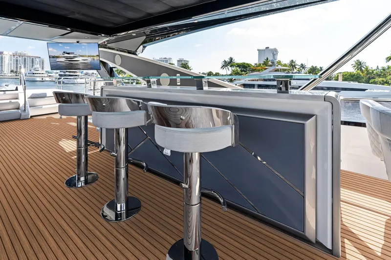 Don Tortuga Yacht Photos Pics Luxurious Sunseeker Ocean 90 yacht deck with bar stools, 2024 model, docked in a marina.