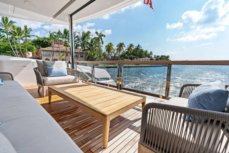 Don Tortuga Yacht Photos Pics Luxurious Sunseeker Ocean 90 yacht deck with elegant seating, overlooking serene ocean and palm trees.
