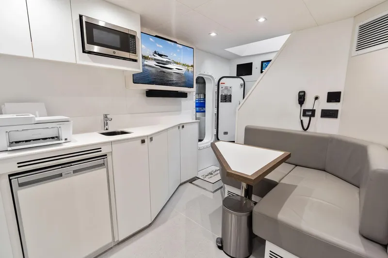 Don Tortuga Yacht Photos Pics Modern interior of 2024 Sunseeker Ocean 90 yacht with kitchenette and seating area.