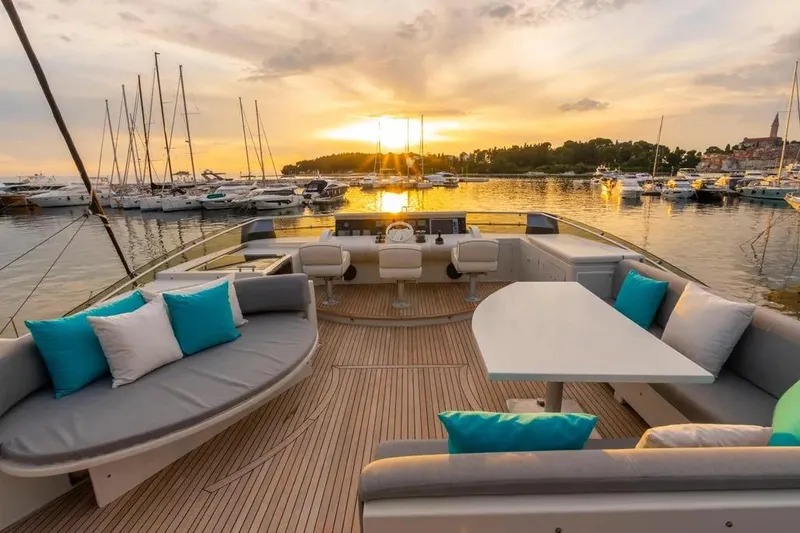  Yacht Photos Pics Luxurious Mochi 2250 yacht deck at sunset, featuring elegant seating and scenic marina views.