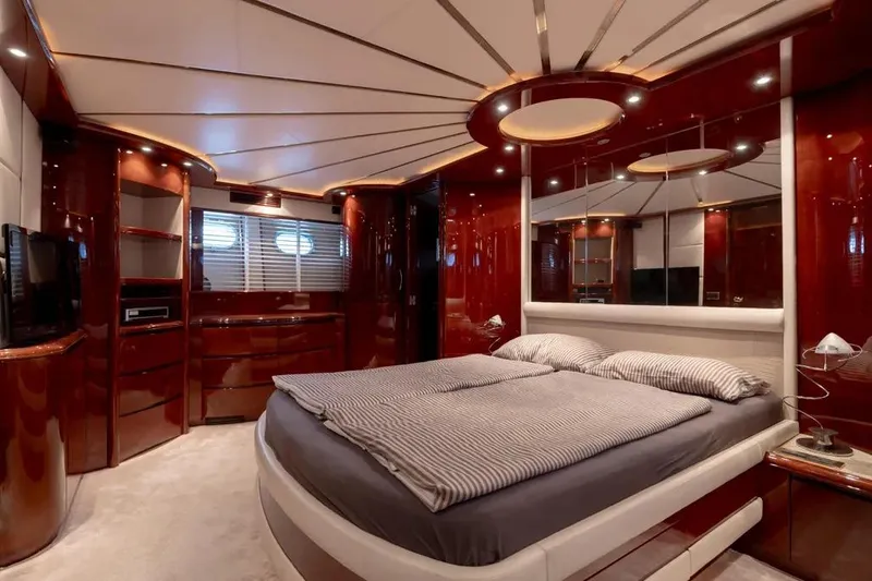  Yacht Photos Pics Luxurious bedroom interior on a 2003 Mochi 2250 yacht, featuring elegant wood finishes.