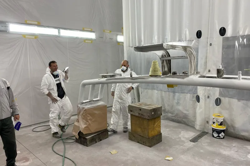  Yacht Photos Pics Workers in protective gear inspect Mochi 2250 model part in a spray booth, 2003.