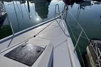 Dehler 30 sailboat deck, 2022 model, docked in a marina with calm water reflections.