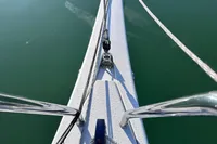 Bow of 2022 Dehler 30 sailboat on calm water, showcasing sleek design and rigging.