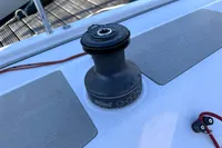 Winch on 2022 Dehler 30 sailboat deck, with red rope and metal fittings.