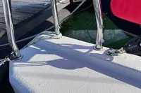 Close-up of a 2022 Dehler 30 yacht deck with railing and dock in background.