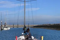 2022 Dehler 30 sailboat navigating a calm marina under a clear blue sky.