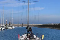 2022 Dehler 30 sailboat navigating a calm marina under a clear blue sky.