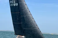 2022 Dehler 30 sailboat navigating on open water under clear blue skies.