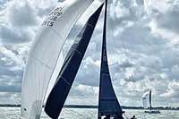 2022 Dehler 30 sailboat navigating under cloudy skies on open water.
