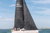 2022 Dehler 30 sailboat on open water under clear blue sky.