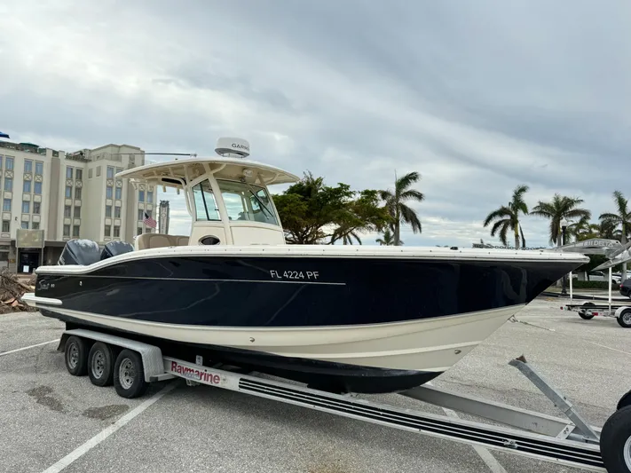  Yacht Photos Pics 2011 Scout 282 XSF boat on trailer in parking lot with palm trees.