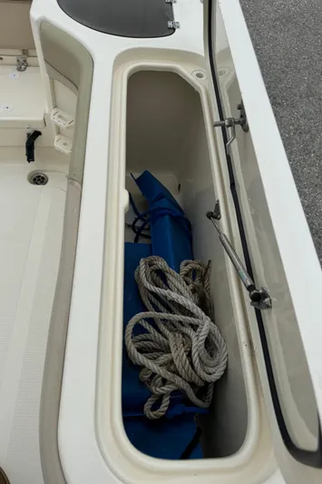  Yacht Photos Pics Open storage compartment on 2011 Scout 282 XSF boat with rope and blue equipment.
