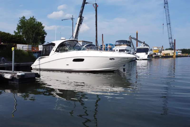  Yacht Photos Pics 2012 Sea Ray 370 Sundancer yacht docked in a marina with cranes in the background.