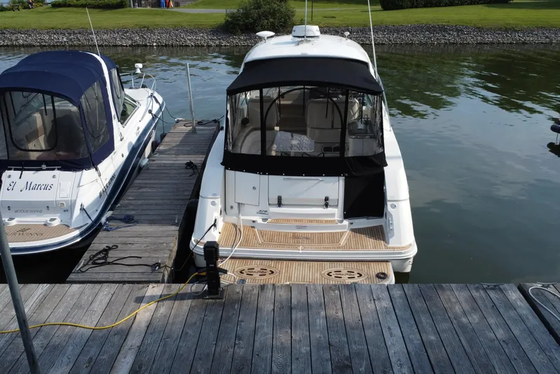  Yacht Photos Pics 2012 Sea Ray 370 Sundancer docked beside another boat on a calm waterway.