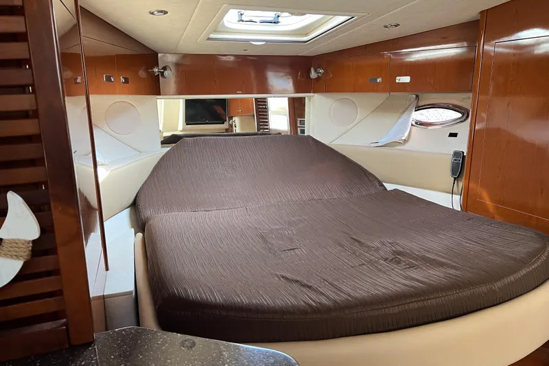  Yacht Photos Pics Luxurious cabin interior of 2012 Sea Ray 370 Sundancer with cozy bed and wooden finishes.