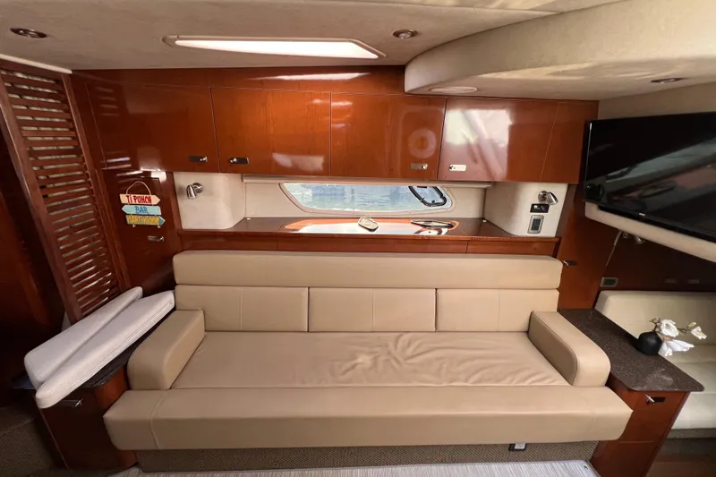  Yacht Photos Pics Luxurious interior of 2012 Sea Ray 370 Sundancer with beige leather seating and wooden cabinetry.
