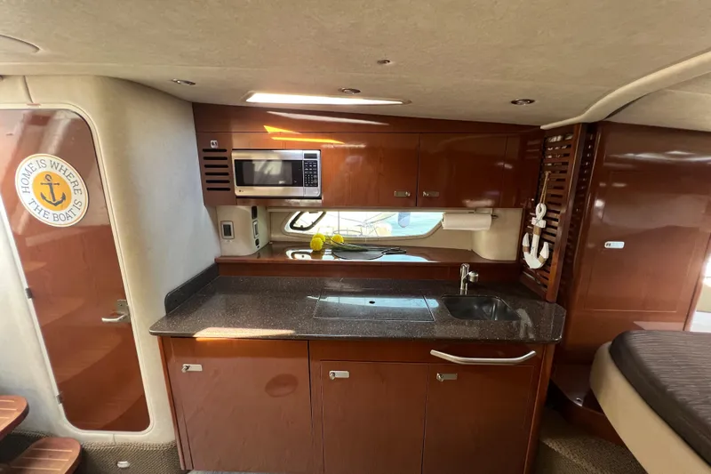  Yacht Photos Pics Interior of 2012 Sea Ray 370 Sundancer yacht with kitchenette and wooden cabinetry.